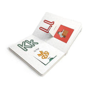 Open book with colorful letters and illustrations on a white background
