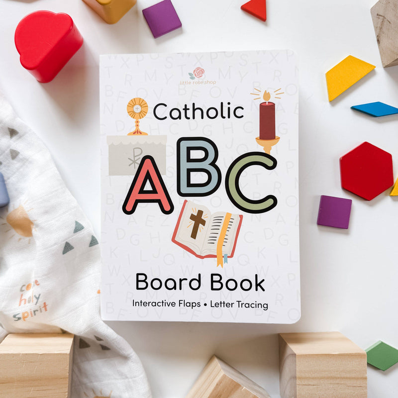 Catholic ABC Board Book surrounded by colorful blocks on a white surface