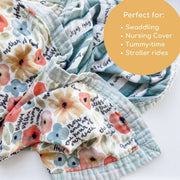 Floral patterned swaddle blanket with text on a white background